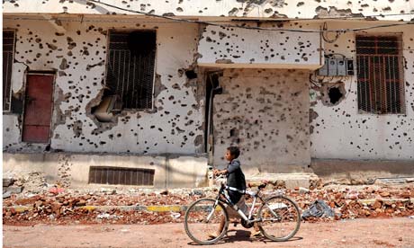A boy walks past a bullet-scarred building in the Yemeni capital, Sana'a.